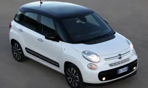 Biały Fiat 500L z czarnym dachem i felgami, zaparkowany na szarym podłożu.