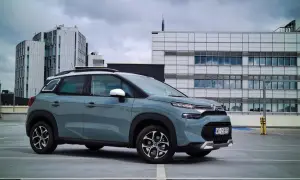 Szary Citroen C3 na parkingu przed nowoczesnymi budynkami. Wiele osób szuka **citroen c3 opinie** przed zakupem.