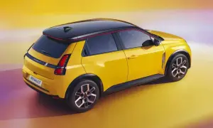 Nowe Renault 5 w jaskrawym żółtym kolorze z czarnym dachem i czerwonymi akcentami, prezentuje nowoczesny design.