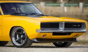 Żółty Dodge Charger 1970 z czarnymi pasami na masce i chromowanym grillem.