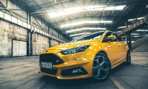Żółty Ford Focus ST 2010 w hangarze, gotowy do akcji.