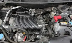 Silnik Nissan Qashqai J10, z widocznym kolektorem dolotowym, akumulatorem i innymi elementami.
