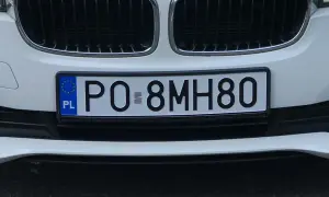 Białe auto z tablicą rejestracyjną PO 8MH80.