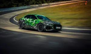 Rs3 Audi w zielono-czarnej kamuflażowej okleinie pędzi po torze wyścigowym.