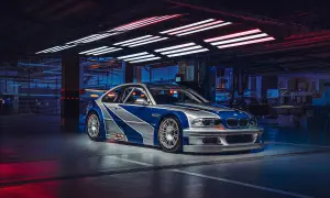 Wyścigowe e46 BMW M3 GTR w garażu, z niebiesko-srebrnym malowaniem, gotowe do akcji.