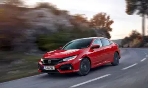 Czerwony Honda Civic 10 na zakręcie drogi, z rozmytym tłem gór i drzew.