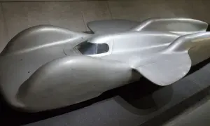 Srebrny, opływowy Mercedes T80, legendarny samochód wyścigowy, prezentuje swoje aerodynamiczne kształty.