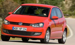 Czerwony vw polo 2010 na zakręcie drogi.