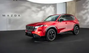 Błyszcząca, czerwona, nowa Mazda CX-5 prezentowana na czarnej scenie.