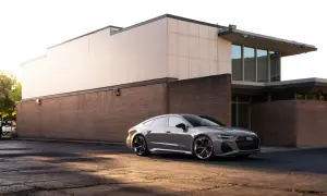 Elegancki, szary Audi RS7 zaparkowany przed nowoczesnym budynkiem.