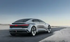 Srebrny Audi A9, futurystyczny koncept, jedzie po pustej drodze.