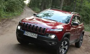 Czerwony Jeep Cherokee Trailhawk na leśnej, piaszczystej drodze. Gotowy na przygodę.