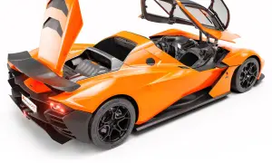 Pomarańczowy KTM X-Bow z otwartymi drzwiami i maską, odsłaniający wnętrze i silnik. Wyścigowy wygląd z karbonowymi elementami.
