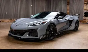 Szary Chevrolet Corvette C8 z czarnymi felgami i spojlerem, gotowy do jazdy.