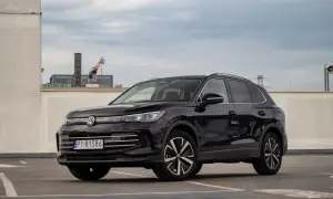 Czarny Volkswagen Tiguan 2020 na parkingu, z widocznym fragmentem miasta w tle.