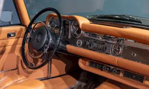 Wnętrze klasycznego **Mercedes Pagoda** z brązową skórzaną tapicerką, chromowanymi detalami i radiem Becker.