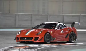 Czerwony Ferrari FXX K z numerem 4 na torze wyścigowym, gotowy do pokonania kolejnego zakrętu.