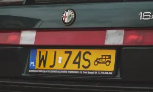 Nowe tablice rejestracyjne z symbolem starego auta na zielonym Alfa Romeo 164.