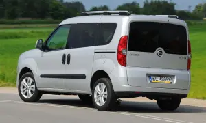 Srebrny Opel Combo C w ruchu, z tyłu widoczny bagażnik dachowy i przyciemniane szyby.