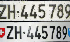 Dwie tablice rejestracyjne z numerem ZH 445789. Górna jest starsza, dolna ma herb Szwajcarii i kantonu Zurych.