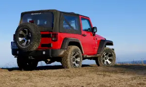 Czerwony Jeep Wrangler, gotowy na każdą wyprawę, niczym przekraczający Rubikon.