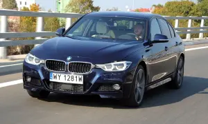Ciemnoniebieskie BMW F30 M Pakiet pędzi po drodze. Kierowca skupiony na trasie.