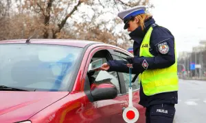 Policjantka kontroluje dokumenty kierowcy. Czy trzeba mieć przy sobie dowód rejestracyjny? Tak, w Polsce jest to obowiązkowe.