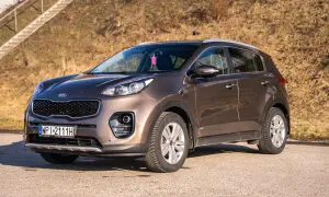 Brązowy Kia Sportage 2020 zaparkowany na tle suchej trawy i schodów.
