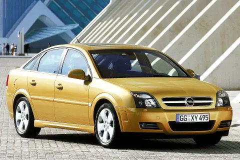 Złoty Opel Vectra C 1.9 CDTI 120 KM prezentuje się elegancko na tle nowoczesnej architektury. Opinie o tym modelu często podkreślają jego komfort i oszczędność.