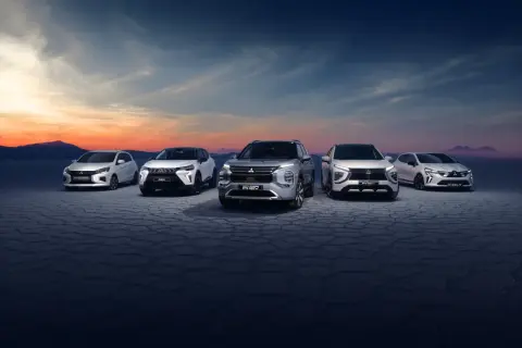 Pięć modeli Mitsubishi ustawionych na pustynnym tle o zachodzie słońca.