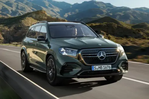 Zielony Mercedes-Benz GLS przemierza malowniczą, górską drogę.