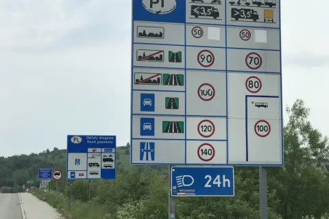 Znaki drogowe z ograniczeniami prędkości i informacją o opłatach drogowych w Polsce.