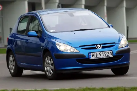 Niebieski Peugeot 307 1.6 benzyna z polskimi tablicami WI 91924 jedzie po drodze.