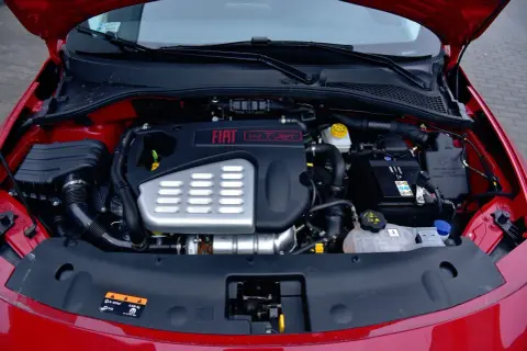 Silnik 1.4 T-Jet w czerwonym Fiat Tipo. Widoczny akumulator, płyny i elementy układu dolotowego.