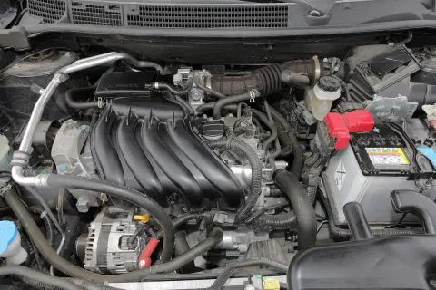 Silnik Nissan Qashqai J10, z widocznym kolektorem dolotowym, akumulatorem i innymi elementami.