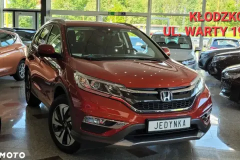 Czerwona Honda CR-V 4 generacji w salonie samochodowym.