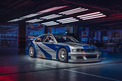Wyścigowe e46 BMW M3 GTR w garażu, z niebiesko-srebrnym malowaniem, gotowe do akcji.