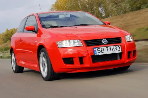 Czerwony Fiat Stilo 1.9 JTD w ruchu, z widocznym zderzakiem i tablicą rejestracyjną SB 71693.