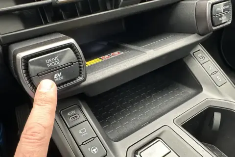 Palec naciska przycisk EV MODE na panelu Toyota. Dowiedz się, co to drive mode Toyota i jak wpływa na jazdę.