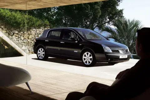 Czarny Renault Vel Satis zaparkowany na tarasie z widokiem na morze. Mężczyzna siedzi w fotelu, podziwiając auto.