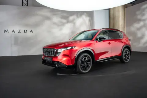 Błyszcząca, czerwona, nowa Mazda CX-5 prezentowana na czarnej scenie.