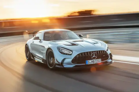 Srebrny Mercedes-AMG GT Black Series na torze wyścigowym, w promieniach zachodzącego słońca.