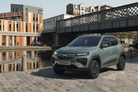 Dacia Spring Electric, miejski samochód elektryczny, zaparkowany nad kanałem w słoneczny dzień.