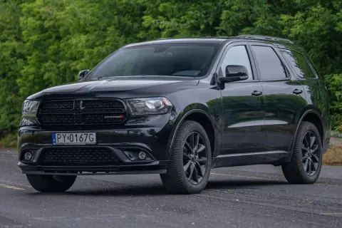 Czarny Dodge Durango 3.6, lśniący na tle zieleni, gotowy na każdą podróż.
