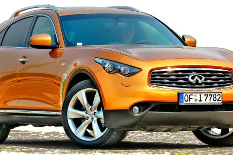 Pomarańczowy **Infiniti samochód** z chromowanymi detalami i felgami stoi na tle białej przestrzeni.