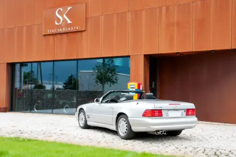 Srebrny SL 500 stoi przed budynkiem "Stacja Klasyki".