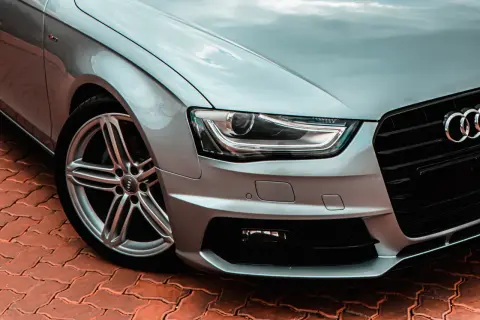Srebrne Audi z reflektorami bixenon, które zapewniają doskonałą widoczność dzięki technologii xenon.