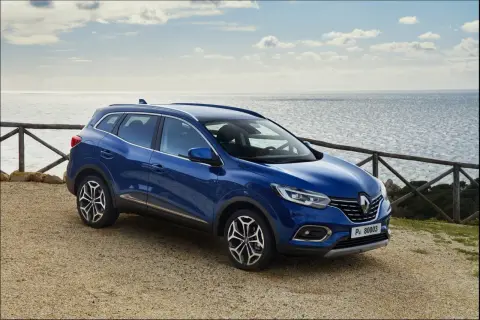 Niebieski Renault Kadjar na tle morza. Wiele pozytywnych **renault kadjar opinie** potwierdza jego wszechstronność.