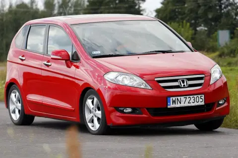 Czerwona Honda FR-V na drodze, z widocznym logo i tablicą rejestracyjną.