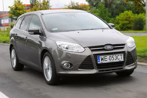 Szary Ford Focus 2012 na drodze, z widocznym numerem rejestracyjnym WE 053CT.
